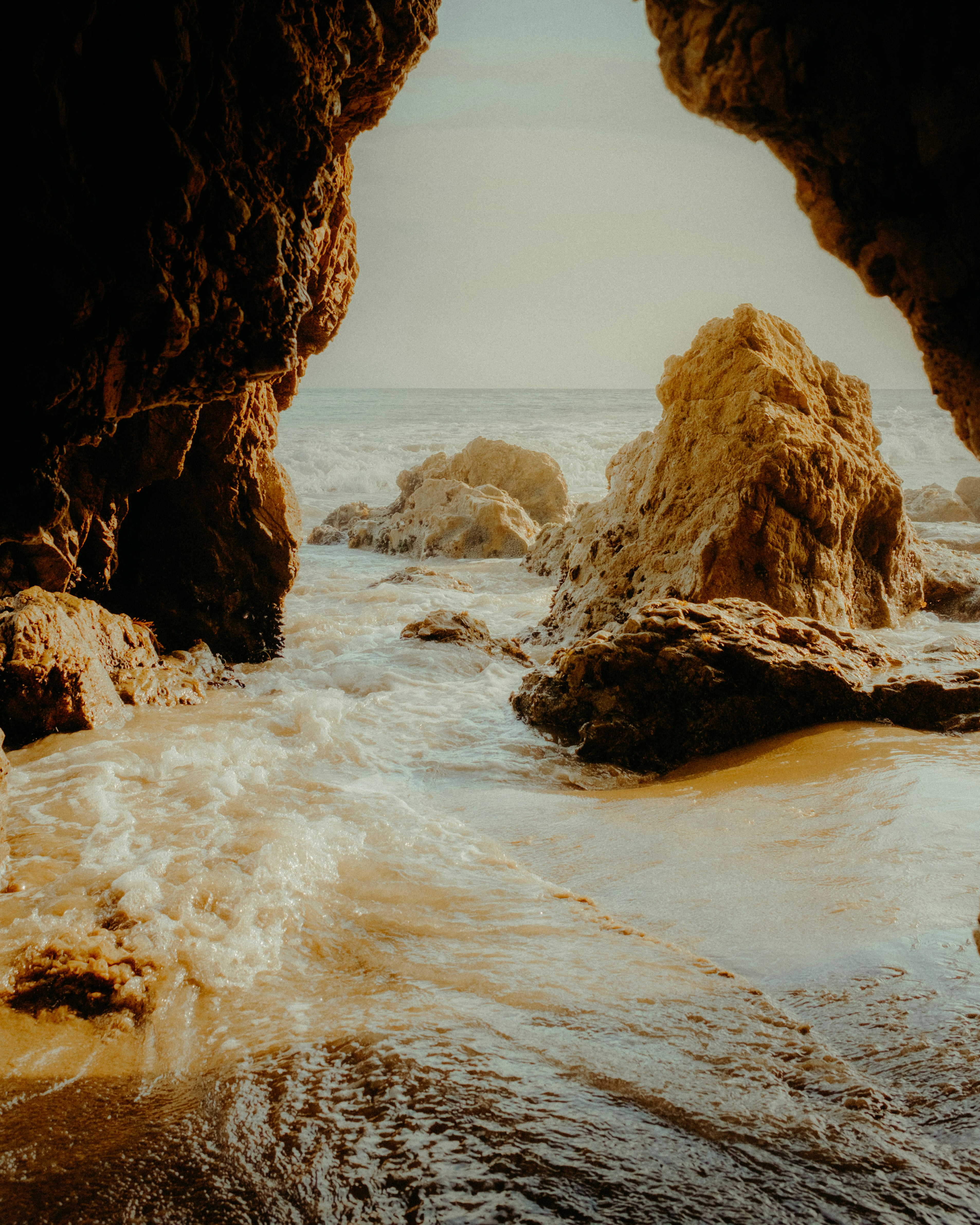 brown rock formation on sea during daytime